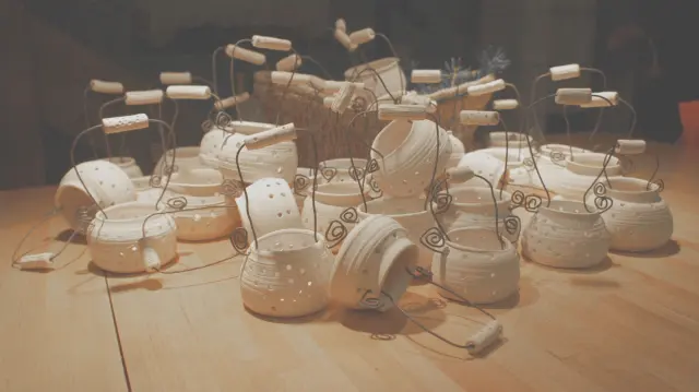 Pots with wire handles and wooden toggles on a table